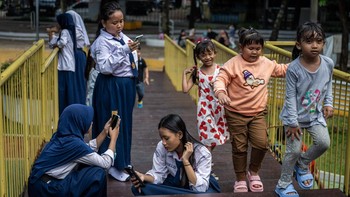 Pelajar memanfaatkan akses internet publik (JakWiFi) milik Pemprov DKI Jakarta untuk belajar di Taman Puring, Jakarta, Kamis (16/10/2025). ANTARA FOTO/Bayu Pratama S