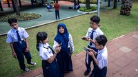 Pelajar memanfaatkan akses internet publik (JakWiFi) milik Pemprov DKI Jakarta untuk belajar di Taman Puring, Jakarta, Kamis (16/10/2025). Pemerintah terus berupaya menciptakan ruang digital yang ramah anak salah satunya melalui penerbitan Peraturan Pemerintah tentang Tunas Anak Indonesia (PP Tunas) yang mendorong peningkatan literasi digital, keamanan siber serta partisipasi anak dalam ekosistem digital yang sehat. ANTARA FOTO/Bayu Pratama S