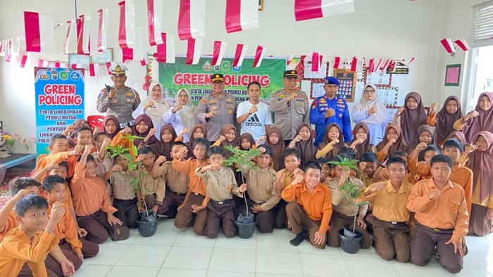 Polisi dan Duta Green Policing Polres Meranti mengedukasi anak SD untuk cinta lingkungan.