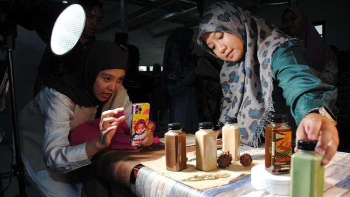 Pelaku UMKM Kota Bogor memotret produk minuman dengan gawainya saat pelatihan foto produk di Gedung DPRD Kota Bogor, Jawa Barat, Kamis (16/10/2025). Pelatihan foto produk yang diselenggarakan Dinas Koperasi Usaha Kecil, Menengah, Perdagangan dan Perindustrian Kota Bogor tersebut diikuti sebanyak 80 pelaku UMKM Kota Bogor untuk meningkatkan daya saing dan penjualan produknya di era digital. ANTARA FOTO/Arif Firmansyah