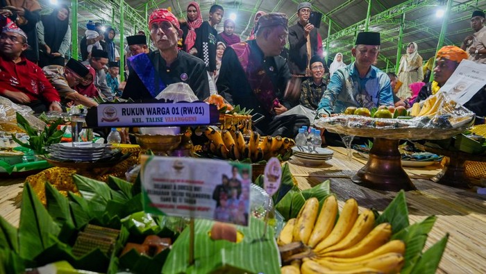 Sejumlah pemuka adat duduk bersila di depan aneka makanan yang disajikan dalam baki pada Festival 1000 Baki Salama Valangguni di Kelurahan Talise Valangguni, Palu, Sulawesi Tengah, Kamis (16/10/2025) malam. Lembaga adat setempat menggelar festival tradisi tahunan Kampung Adat Talise Valangguni yang kini genap berusia 11 tahun dengan menyajikan 1000 baki aneka makanan hasil swadaya masyarakat sebagai simbol syukur, keselamatan dan solidaritas yang disantap bersama. ANTARA FOTO/Basri Marzuki/bar
