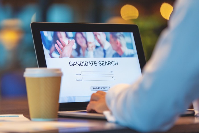 Businessman looking at recruitment website on a laptop computer. Candidate search page with job type, resume and location buttons