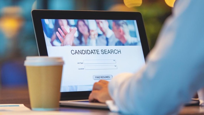 Businessman looking at recruitment website on a laptop computer. Candidate search page with job type, resume and location buttons