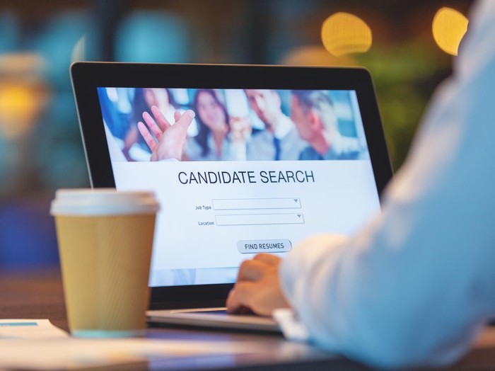 Businessman looking at recruitment website on a laptop computer. Candidate search page with job type, resume and location buttons