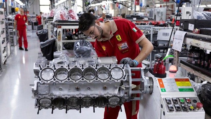 A Ferrari technician works next to assembled Ferrari cars inside the company's factory in Maranello, Italy, October 2, 2025. REUTERS/Remo Casilli