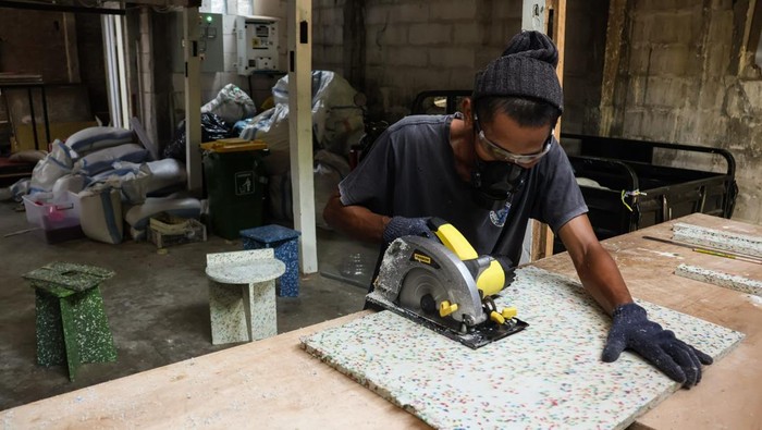 Pekerja menyelesaikan pembuatan kursi berbahan sampah plastik di rumah produksi Rappo Indonesia di Makassar, Sulawesi Selatan, Kamis (16/10/2025). Rumah produksi tersebut mendaur ulang sampah plastik jenis HDPE (high desity polyethylene) dan PP (polypropylene) menjadi perabot seperti kursi dan meja yang dipasarkan ke sejumlah daerah di Indonesia dengan kapasitas pengolahan mencapai tiga ton sampah per bulan. 
ANTARA FOTO/Arnas Padda/nz