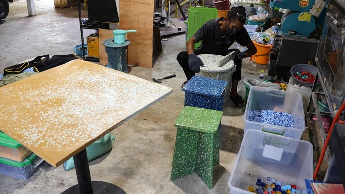 Pekerja menyelesaikan pembuatan kursi berbahan sampah plastik di rumah produksi Rappo Indonesia di Makassar, Sulawesi Selatan, Kamis (16/10/2025). Rumah produksi tersebut mendaur ulang sampah plastik jenis HDPE (high desity polyethylene) dan PP (polypropylene) menjadi perabot seperti kursi dan meja yang dipasarkan ke sejumlah daerah di Indonesia dengan kapasitas pengolahan mencapai tiga ton sampah per bulan. 
ANTARA FOTO/Arnas Padda/nz