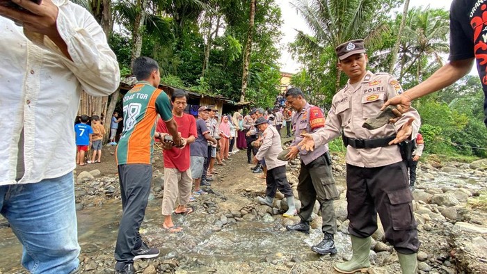 Puluhan personel Polres Purbalingga bersama sejumlah instansi dan warga dalam menangani jalan utama desa yang amblas akibat longsor di Desa Panusupan, Rembang, Rabu (15/10/2025).