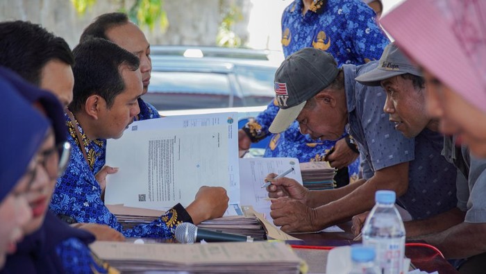 Warga penerima sertifikat tanah program Pendaftaran Tanah Sistematis Lengkap (PTSL) mengisi data di Balai Desa Jugosari, Lumajang, Jawa Timur, Jumat (17/10/2025). Badan Pertanahan Nasional (BPN) Lumajang menyerahkan sebanyak 6.000 sertifikat tanah program PTSL tahun 2025 secara bertahap, baik dalam bentuk fisik maupun elektronik, guna mencegah terjadinya penggandaan atau penipuan sertifikat. ANTARA FOTO/Irfan Sumanjaya/foc.