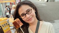 Momen kulinerannya di Korea juga terlihat jajan di warung kaki lima. Ia membeli es krim yang dibalut dengan marshmallow. Foto: Instagram/@prillylatucona96
