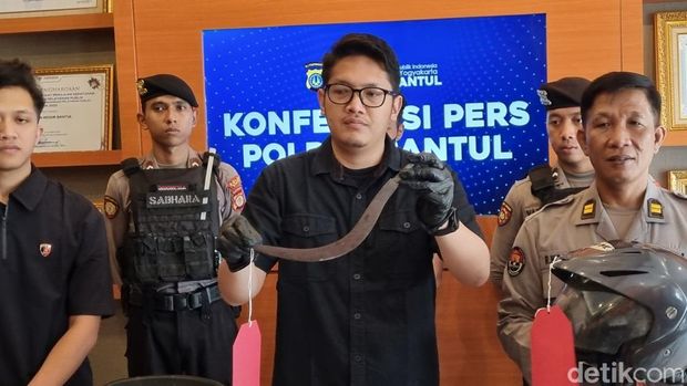 Tersangka penganiayaan driver ojol menggunakan celurit, IGS (26) saat dihadirkan di Polres Bantul, Jumat (17/10/2025).