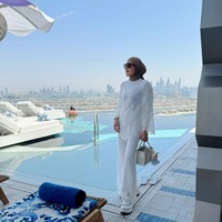 Terlepas dari tuduhan hedonisme, dalam sejumlah foto yang diunggah di Instagram, Erin kerap menampilkan gaya modest yang simple namun tetap terkesan elegan. Seperti saat pose di tepi kolam infinity pool, dia mengenakan busana serba putih berbahan lace. Gaya ini tampak segar dan bersih, dilengkapi sandal platform putih dan tas mini bertekstur yang memperkuat kesan resort look. Foto: Instagram/@erintaulany