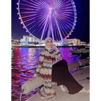 Saat malam hari, Erin mengenakan outer bermotif zigzag bernuansa earthy tone yang flowy, dipadu celana hitam lebar dan hijab putih. Look ini terasa glam namun tetap santai. Foto: Instagram/@erintaulany