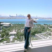 Kemeja putih klasik dan wide-leg jeans menjadi pilihan Erin saat menikmati pemandangan kota. Gaya ini sederhana namun berkelas, dilengkapi aksesori jam tangan emas dan kacamata besar yang memberi sentuhan old-money vibes. Foto: Instagram/@erintaulany