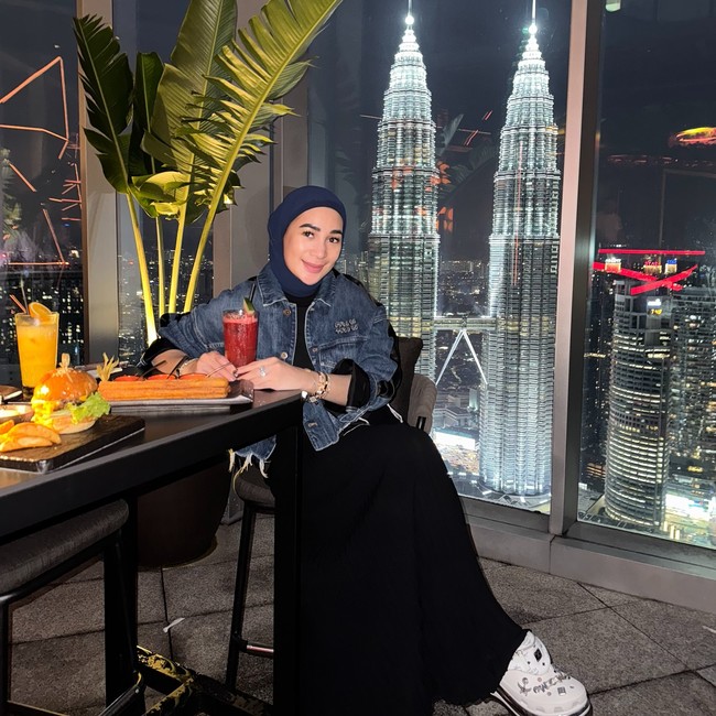 Erin menunjukkan gaya urban dengan jaket denim dipadukan hijab navy dan celana hitam lebar. Sneakers putih detail grafis memberi sentuhan playful. Foto: Instagram/@erintaulany