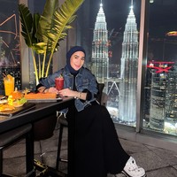 Erin menunjukkan gaya urban dengan jaket denim dipadukan hijab navy dan celana hitam lebar. Sneakers putih detail grafis memberi sentuhan playful. Foto: Instagram/@erintaulany