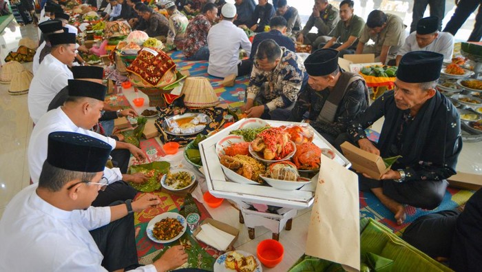 Sejumlah peserta mengikuti makan bajamba pada rangkaian Mauluik Gadang di Masjid Raya Padang Pariaman, Sumatera Barat, Sabtu (18/10/2025). Makan Bajamba merupakan tradisi makan bersama pada budaya Minangkabau yang melambangkan kebersamaan, kesetaraan, dan kekeluargaan, serta sering diadakan pada acara adat seperti pernikahan, upacara kebesaran, atau pertemuan penting lainnya. ANTARA FOTO/Iggoy el Fitra/bar