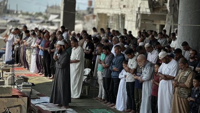 KHAN YUNIS, GAZA - OCTOBER 17: Palestinians perform Friday prayers amid the rubble of Al-Albani Mosque, destroyed during Israeli attacks, in Khan Yunis, southern Gaza, on October 17, 2025. (Photo by Doaa Albaz/Anadolu via Getty Images)