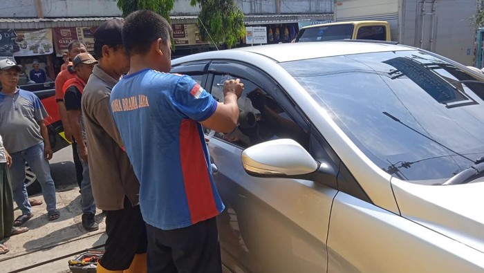 Petugas Damkar mengevakuasi anak yang terkunci dalam mobil di Jalan Kalimantan, tepatnya di depan Pasar Tanjungsari, Kebonmanis, Kabupaten Cilacap, Sabtu (18/10/2025).