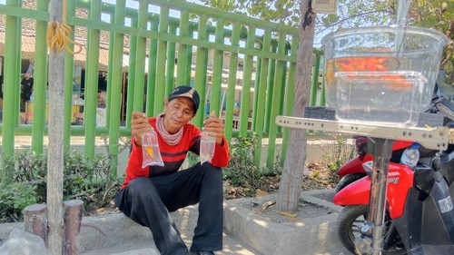 Abdul Gani Murad, difabel penjual ikan hias menunjukan dagangannya saat berjualan di Puskesmas Batuyang, Kecamatan Pringgabaya, Lombok Timur, NTB, Minggu (18/10/2025) siang. (Sanusi Ardi W/detikBali)