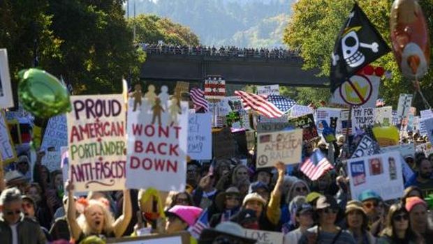 PORTLAND, OREGON - OCTOBER 18: Demonstrators cheer during a speech as protesters gather to march for the 
