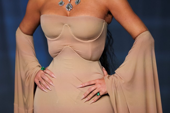 Kim melengkapi gayanya dengan kalung statement bertabur belian yang membungkus penuh leher. Tidak ketinggalan cincin berbatu zamrud yang besar. (Foto: REUTERS/Mario Anzuoni)