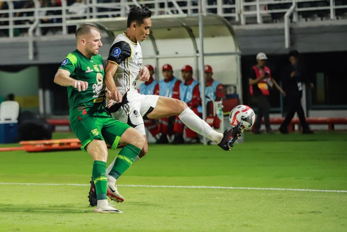 Pesepak bola Persebaya Surabaya Mihailo Perovic (kanan) menendang bola yang dihadang penjaga gawang Persija Jakarta Carlos Eduardo Soares Mota (kedua kanan) pada pertandingan BRI Super League di Stadion Gelora Bung Tomo, Surabaya, Jawa Timur, Sabtu (18/10/2025). Persija Jakarta menang 3-1 atas Persebaya Surabaya. ANTARA FOTO/Rizal Hanafi