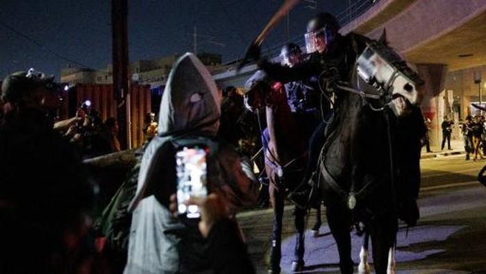LOS ANGELES, CALIFORNIA - OCTOBER 18: Protesters and mounted Los Angeles Police Department officers clash outside the Metropolitan Detection Center after an unlawful assembly was declared during the 