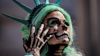 Di Los Angeles, para demonstran memadati area sekitar Balai Kota dengan membawa poster dan mengenakan berbagai kostum kreatif, termasuk sosok bergaya Patung Liberty serta riasan khas Catrina. REUTERS/Daniel Cole
