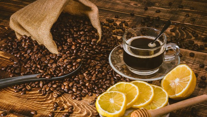 Coffee cup and beans on old kitchen table. Top view with copy space for your text. coffee bag and with sliced 