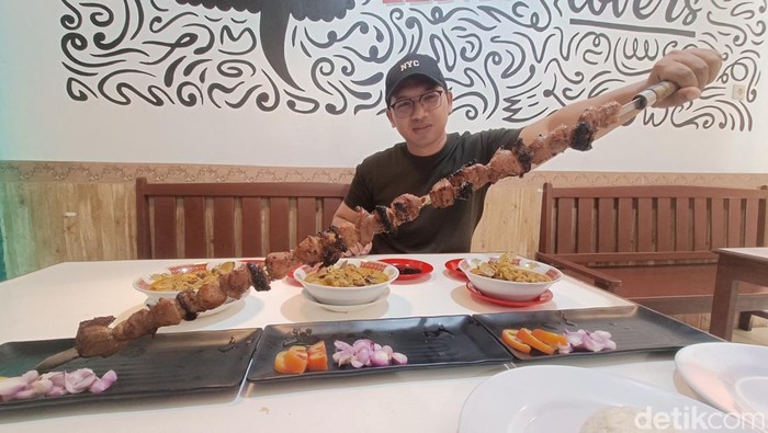 Penampakan sate kambing tusuk pedang sepanjang 1 meter di outlet sate KMC, Purwokerto Utara, Kabupaten Banyumas, Senin (20/10/2025).