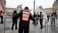 Petugas keamanan berjaga di depan Museum Louvre, Paris, Senin (20/10/2025). Penutupan sementara dilakukan sehari setelah pencuri bersenjata terekam membobol ruang koleksi permata mahkota Prancis. Foto: REUTERS/Benoit Tessier