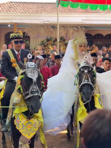 Pernikahan Madura Viral Suasana resepsi pernikahan di Madura, Jawa Timur ini mendadak jadi sorotan dan viral di media sosial, pasangan pengantin kompak diarak naik kuda dan ada kerapan sapi.