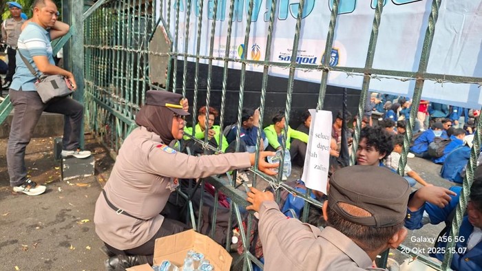 Polda jateng berikan air Personel Polda Jateng saat memberikan air kepada massa unjuk rasa di depan Kantor Gubernur Jateng.