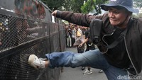 Massa sempat mendorong dan menendang barikade yang dijaga polisi. Polisi mengimbau anggotanya tidak terpancing.  