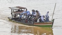 Warga menumpang perahu penyeberangan itu dengan tarif umum Rp7 ribu per motor pulang-pergi (PP) dan Rp5 ribu per motor PP untuk pelajar karena tidak adanya jembatan penghubung. Foto: ANTARA FOTO/Wahdi Septiawan  