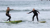Inisiatif Moms on Board, yang dijalankan oleh Lifestyle Surf Shop, menawarkan papan selancar, pakaian selam, dan sesi pelatihan gratis bagi para ibu yang ingin beristirahat sejenak dari tanggung jawab sehari-hari mereka. Foto: REUTERS/Esa Alexander