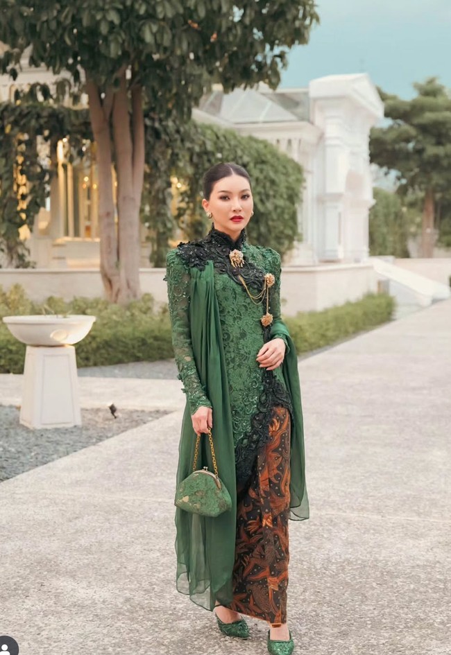 Ia melengkapi tampilannya dengan bros dan rantai berwarna emas yang disematkan di dada, serta anting bundar berornamen klasik. Sarwendah juga memilih tas kecil berwarna hijau dengan tali rantai emas serta sepatu pointed heels hijau berkilau yang senada dengan kebayanya. Foto: Instagram/@sarwendah29