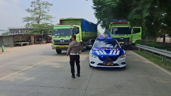 Satlantas Polres Serang menertibkan truk tambang yang melanggar jam operasinal di Jalan Raya Cikande–Rangkasbitung, Serang, Banten.