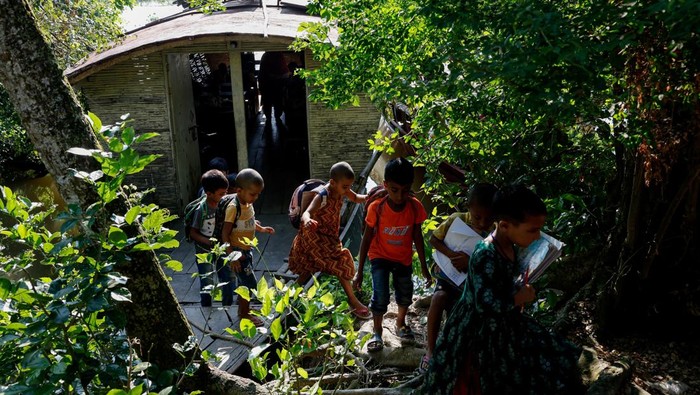 Sekolah Perahu Jadi Harapan Anak-Anak di Negeri yang Selalu Terendam Students read books inside a floating library built on a boat by an NGO named Shidhulai Swanirvar Sangstha, in Bhangura area of Pabna, Bangladesh, September 25, 2025. REUTERS/Mohammad Ponir Hossain