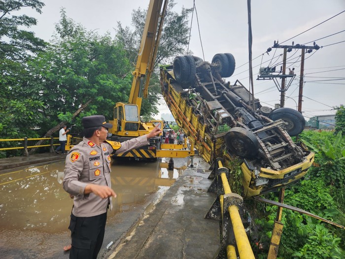 Truk yang membawa pasir terjatuh dari jembatan Cisauk, Kabupaten Tangerang, Banten. Sopir truk mengalami luka akibat kecelakaan itu. (dok Polsek Cisauk)
