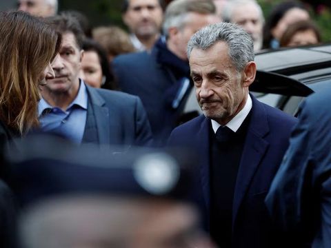 Mantan Presiden Prancis Nicolas Sarkozy sebelum meninggalkan rumahnya menuju ke Penjara La Sante untuk memulai masa hukumannya Former French President Nicolas Sarkozy stands next to his wife Carla Bruni-Sarkozy before leaving in a car on the day of his incarceration at the Sante prison to begin his five-year prison sentence for criminal conspiracy over attempts to raise campaign funds from Libya, in Paris, France, October 21, 2025. REUTERS/Benoit Tessier Purchase Licensing Rights