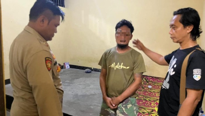 Pelaku penganiayaan (tengah) saat diamankan oleh polisi di Polsek Kretek, Bantul.
