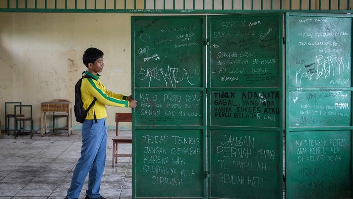 Siswa menarik pintu pembatas kelas di SMK Al-Anshor, Legok, Kabupaten Tangerang, Banten, Selasa (21/10/2025). Menurut keterangan siswa, sekolah tersebut menghentikan kegiatan belajar mengajar tatap muka sejak Agustus 2025 dengan kondisi sarana dan prasarana yang rusak, serta jumlah siswa aktif tersisa sebanyak 26 orang dan empat guru yang hingga kini masih menanti kejelasan terkait kelanjutan masa depan pendidikannya. ANTARA FOTO/Putra M. Akbar/rwa.