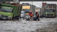 Dua warga mendorong sepeda motornya yang mogok seusai menembus genangan banjir di jalur utama pantura Semarang-Surabaya, Jalan Kaligawe Raya, Semarang, Jawa Tengah, Rabu (22/10/2025). Foto: ANTARA FOTO/Aji Styawan