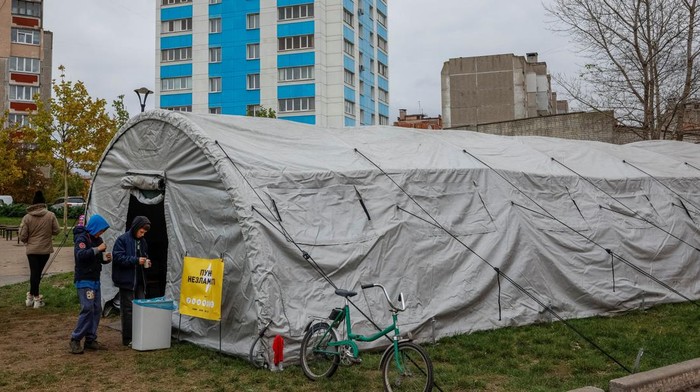 Dingin Menyengat, Warga Ukraina Berlindung di Tenda Darurat Usai Serangan Rusia People gather around an invincibility centre, where they can use Internet connection, charge their devices and warm up, amid water and electricity supply outage, after critical infrastructure was hit during a Russian drone attack, in Chernihiv, Ukraine October 21, 2025. REUTERS/Alina Smutko