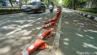 Kondisi pembatas jalur sepeda yang rusak di Jalan Perintis Kemerdekaan menandakan perlunya perawatan rutin demi keselamatan dan ketertiban lalu lintas.