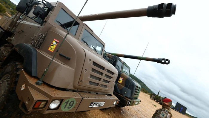 Meriam Tempur CAESAR Menjadi Bintang di Pameran Militer Prancis Selatan A soldier stands in front of two stationary Caesar self-propelled howitzer during a