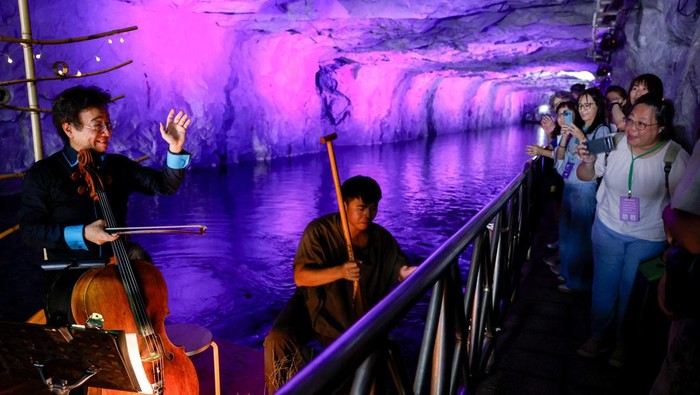 Musik dan Cahaya Hidupkan Terowongan Perang Taiwan yang Sunyi Taiwanese opera singer Wei Hai-min performs on a raft inside the Zhaishan Tunnel during the annual Kinmen Tunnel Music Festival in Kinmen, Taiwan, October 19, 2025. REUTERS/Ann Wang