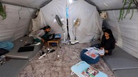Berjuang dengan keterbatasan internet dan listrik, Mhanna sering mengandalkan senter ponselnya untuk belajar. Sebelum ujian, Mhanna berjalan jauh untuk mengikuti les privat, karena sistem pendidikan Gaza hancur lebur. Kembali ke tendanya setiap malam, siswa yang mengungsi dari Kota Gaza ini juga merawat saudara-saudara perempuannya dan mengurus pekerjaan rumah tangga. REUTERS/Mahmoud Issa